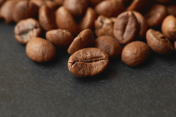 Roasted coffee beans isolated in dark  background. Espresso dark, aroma, black caffeine drink.