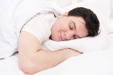Fototapeta na wymiar Brunette man sleeping in bed