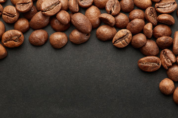 Brown roasted coffee beans on dark background. Espresso dark, aroma, black caffeine drink. Closeup isolated energy mocha, cappuccino ingredient.