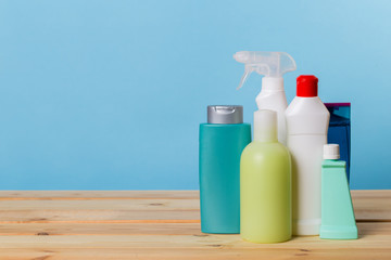 Cleaning product plastic container for house clean on wooden table and blue background . household chemicals