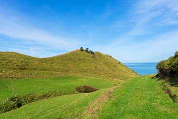 Green mountains in Zumaia under blue sky