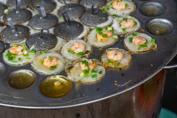 Sizzling Vietnamese tiny shrimp pancake on skillet- Banh Khot