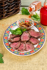 Sliced roast beef served on a plate with sauce