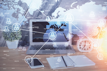 Computer on desktop with social network hologram. Multi exposure. Concept of international people connections.