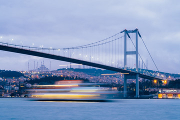 Sunset or Dusk over the First Bosporus Bridge Crossing the Bosphorus or Bosporus Straits Istanbul Turkey. Büyük Çamlıca Camii Mosque and Beylerbeyi  Palace are visible .