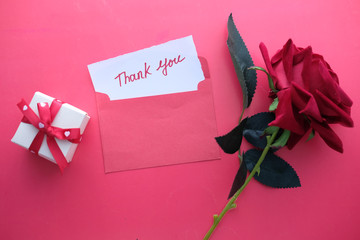 thank you letter and rose flower on red background 