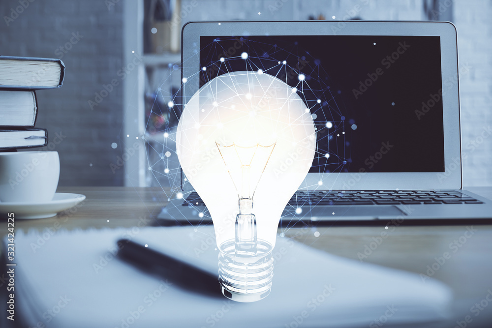 Poster computer on desktop in office with bulb icon hologram. multi exposure. concept of idea.