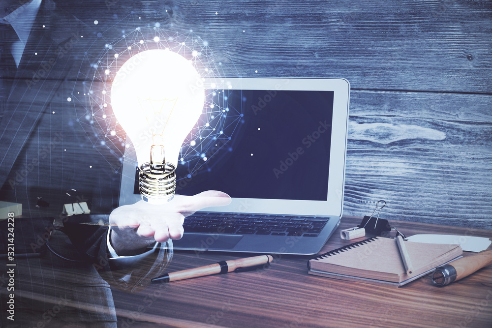Poster computer on desktop in office with bulb icon hologram. multi exposure. concept of idea.