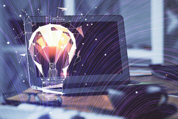 Computer on desktop in office with bulb icon hologram. Multi exposure. Concept of idea.