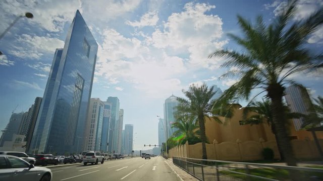 Smooth drive through Doha's business center West Bay during a sunny day.