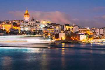 Fototapeta na wymiar Istanbul, Turkey - Jan 15, 2020: Galata Tower with Ferry Boat in Golden Horn , Istanbul, Turkey,