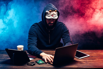 hacker man in mask for sleeping sit with laptop try to get password or to enter pc system, genius...