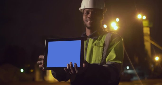 Industrial Workers Wearing Reflective Jackets On Mining Worksite Outdoors Using Digital Tablet