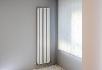 white radiator on gray wall with window