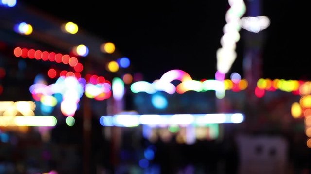 Blurry colorful blinking lights of fairground at night