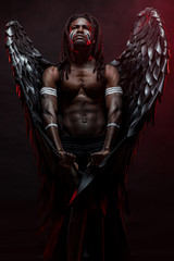 strong muscular angel with black wings fall on the earth, extraordinary african man stand in the...