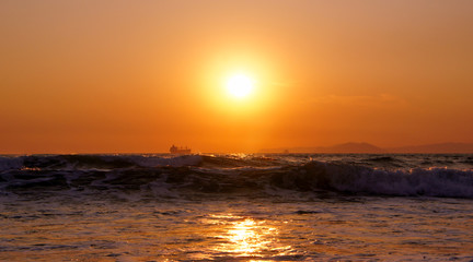 Sunset sea horizon cargo ship silhouette landscape.
