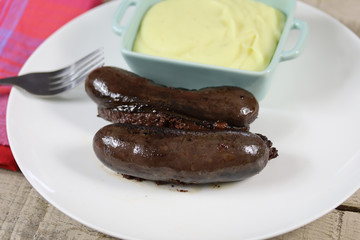 boudin noir cuit et purée dans une assiette
