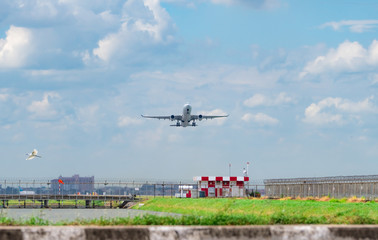 Passenger plane takes off at airport with beautiful blue sky and white fluffy clouds. Leaving...
