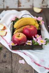 Apples and banannas on a metal tray with flowers