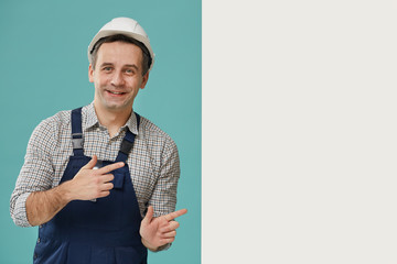 Waist up portrait of cheerful worker pointing to side with blank while canvas for ad sign, copy space