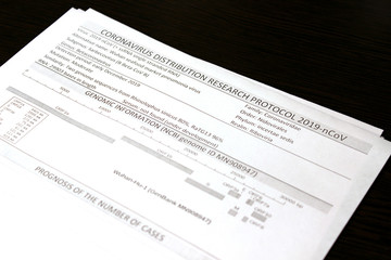 Coronavirus distribution research protocol 2019-nCoV. Information sheets of paper lie on a black surface.