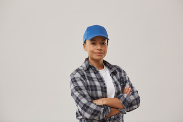 Waist up portrait of beautiful female worker smiling at camera while posing confidently against white background standing with arms crossed, copy space
