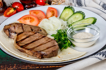 Cooked veal tongue with fresh vegetables. Shot in the decor
