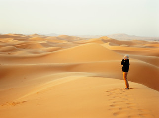 Fototapeta na wymiar person on top of a dune in the sahara desert