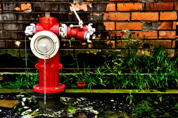 Red fire hydrant against the old brick wall