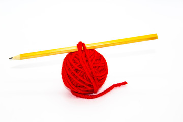 Red skein of thread with the pencil against white background. Red ball of woollen red thread isolated on white