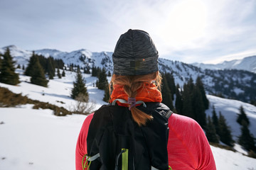 Fototapeta na wymiar Trail runner woman looking at mountains on snow. Woman athlete runner back view