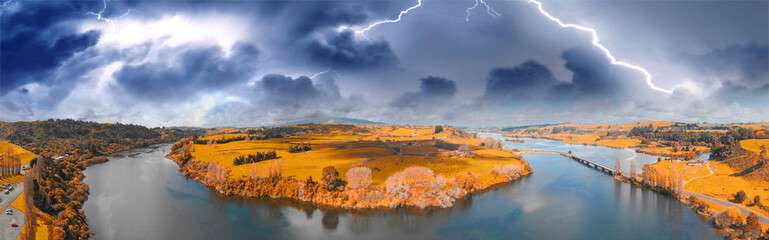 New Zealand panoramic countryside river and meadows, aerial view with storm approaching