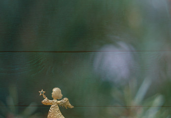 Christmas card with a golden angel in front of a green background with colourful christmas reflections