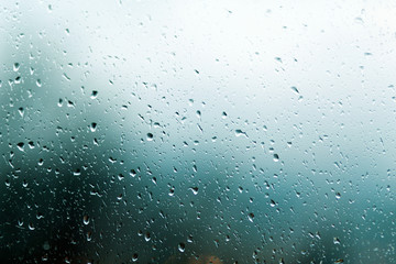 Raindrops on the window, the background is blurred. Dark gray color. Copy space