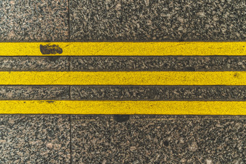 Fototapeta premium Three yellow stripes on the pavement. Restrictive lines
