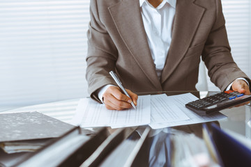 Bookkeeper woman or financial inspector making report, calculating or checking balance, close-up....