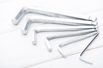 Close up view of metal hek keys on white wooden background