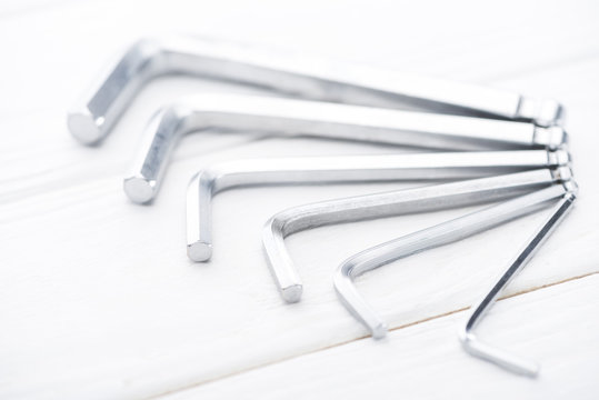 Close up view of metal hek keys on white wooden background