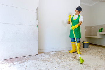 Asian worker cleaning dirty floor