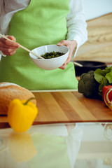 Unknown human hands cooking in kitchen. Woman is busy with vegetable salad. Healthy meal, and vegetarian food concept