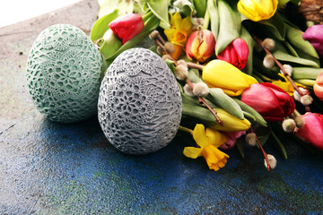 Obraz na płótnie Canvas Easter eggs and tulips and daffodils on rustic background. Springtime decoration