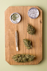 Fototapeta na wymiar marijuana on a wooden board dry and shredded next to a cigarette with marijuana