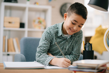 Cute little boy doing homework. Child learning foe school.