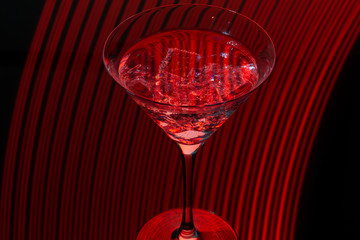 Long exposure martini glass with ice and olives