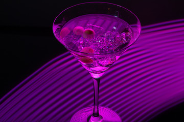 Long exposure martini glass with ice and olives