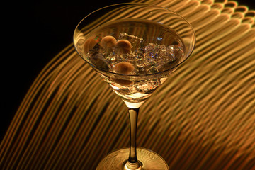 Long exposure martini glass with ice and olives