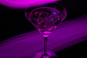 Long exposure martini glass with ice and olives