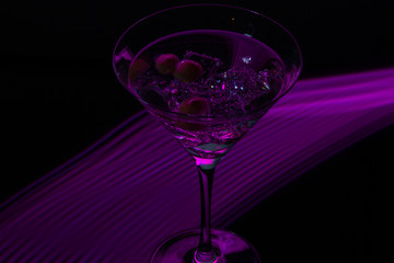 Long exposure martini glass with ice and olives