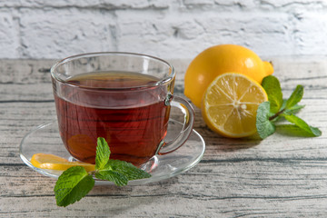 A cup of black tea with lemon on a wooden table